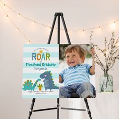 a young boy sitting on top of a easel holding up a sign that says roar