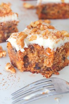 a piece of carrot cake sitting on top of a white plate next to a fork