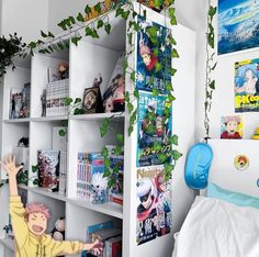 a bedroom with bookshelves and plants on the wall, while a child stands in front of it