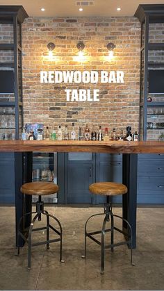 two stools sit at the bar in front of a brick wall