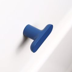 a blue knob on the side of a white wall