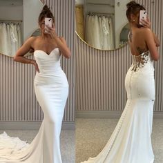 a woman taking a selfie in front of a mirror wearing a white wedding dress