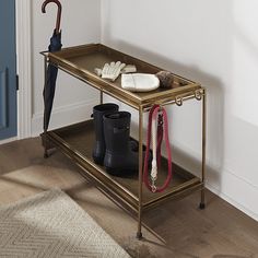 an umbrella and boots are sitting on a shelf next to a door in a room