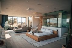 a bed sitting in the middle of a living room next to two couches and windows