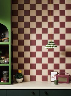 a kitchen with green cabinets and a checkered wallpaper pattern on the back wall