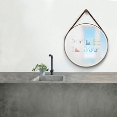 a bathroom sink with a mirror above it and a plant in the corner next to it