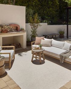 an outdoor living area with white furniture and plants