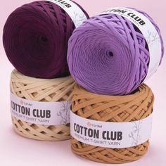 three skeins of yarn sitting on top of each other in purple and tan