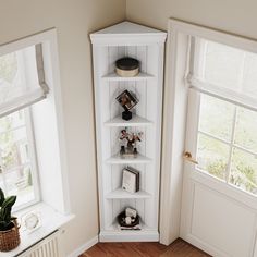 a white book shelf sitting in the corner of a room next to a door and window