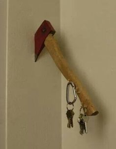 a hammer stuck in the wall with keys attached to it