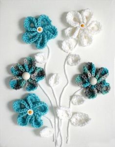 crocheted flowers are arranged on a white surface