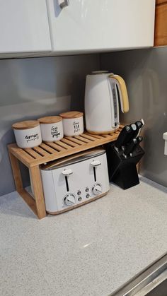 there is a toaster, coffee maker and cups on the counter