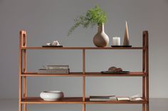 a wooden shelf with books and vases on it