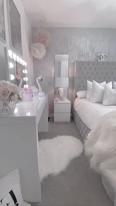 a bedroom with white fur rugs on the floor and pink flowers in vases