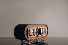 an old fashioned wooden camera with four lens's in it sitting on a table