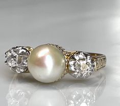 Beautiful art deco era fine quality white pearl and mine cut diamond ring, genuine 7mm cultured pearl ring. Made from 18k yellow and 18K white gold with accents of two sparkling mine cut diamonds. The diamonds measure 3 mm across are estimated SI1 and G in color with a total diamond carat weight for the ring of approximately .20 ct. The setting has stunning detail on nearly every surface! Classic elegance in this unique yet easy to wear design. Ring weight is 3.7 grams.  Details: Pearl measures Pearl Ring Designs Unique, Pearl Ring Vintage, Pearl Ring Design, Pearl Rings Vintage, Cultured Pearl Ring, Antique Engagement Rings Vintage, Engagement Ring Art Deco, Pearl Engagement Ring, Antique Engagement Ring