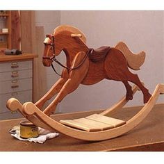 a wooden rocking horse sitting on top of a table