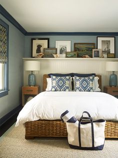 a bedroom with blue walls, white bedding and wicker baskets on the floor