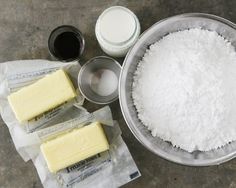 ingredients for making cheesecakes laid out on a table with flour, butter and sugar