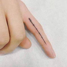 a person's hand with a small arrow tattoo on it