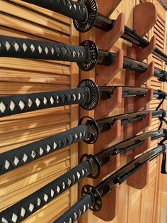 a wooden wall with several pairs of black and white skis hanging on it's side