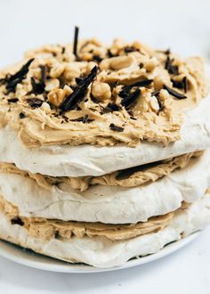 a white plate topped with cake covered in frosting and nuts on top of it