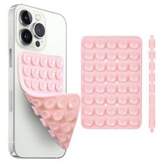 an iphone case with two pieces of pink plastic on it and one piece of white plastic next to the phone