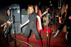 a group of people that are standing in front of some microphones and amps