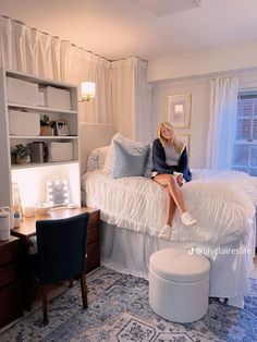 a woman sitting on top of a bed in a bedroom