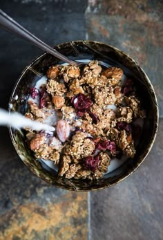 a bowl filled with granola and fruit on top of a table