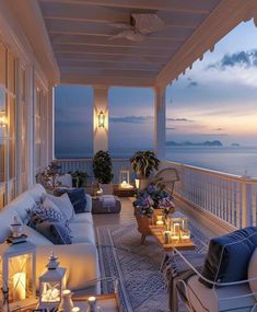 an outdoor living area with wicker furniture and candles lit on the porch overlooking the ocean