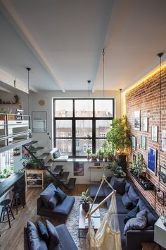 a living room filled with furniture and lots of windows next to a wall mounted tv