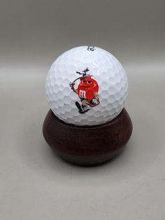 a golf ball on a wooden stand with a drawing of a hockey player