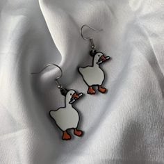 a pair of white and orange duck earrings