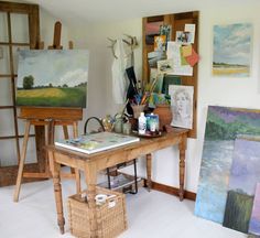 an artist's studio with easels and paintings