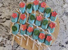 decorated cookies are arranged on a wooden platter