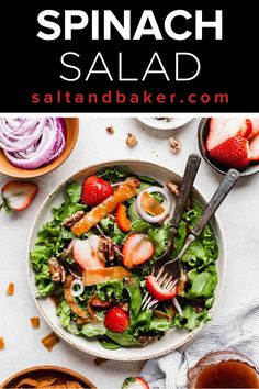 spinach salad in a bowl with strawberries on the side