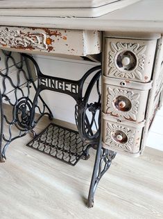 an old sewing machine sitting on top of a wooden table next to a white wall