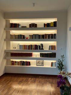 the bookshelves are filled with many different types of books and flowers in vases