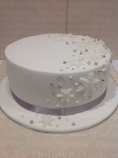 a wedding cake with white frosting and silver decorations