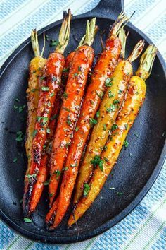 grilled carrots on a black plate with parsley