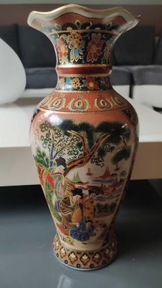 an ornate vase is sitting on a table in front of a couch and coffee table