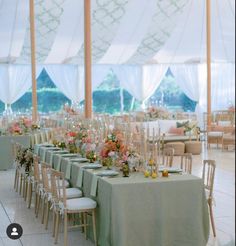 tables set up for an event with chairs and flowers in vases on the table