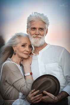 an older man and woman are posing for the camera with their arms around each other