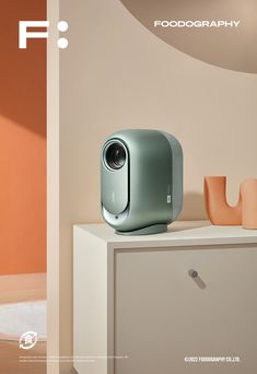 an image of a camera on top of a white cabinet in a room with orange walls