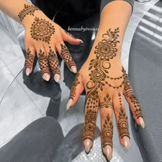 a woman's hand with henna tattoos on it