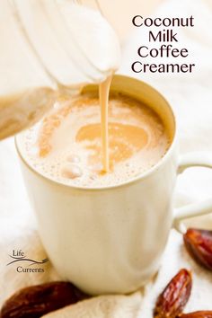 a person pouring milk into a cup filled with hot chocolate and dried raisins