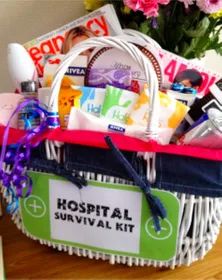 a hospital survival kit in a basket on a table with pink flowers and purple ribbon