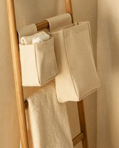 a towel rack with two towels hanging from it's sides and three folded towels on the other side