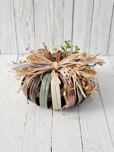 a basket filled with lots of different types of ribbons and flowers on top of a white wooden floor